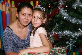 mother with Daughter posing at Christmas tree