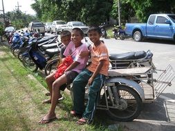 three happy Child boys sitting on scooter, Thailand