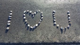 I Love you, pebble lettering with Heart form on grey stone