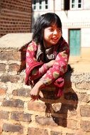 little girl sitting on the wall