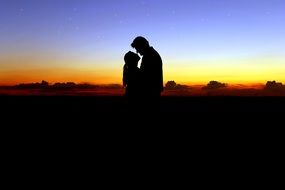 couple in love on top of a mountain against a beautiful sunset