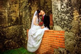 kiss of newlyweds among stone ruins