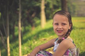 Little girl sitting on a grass