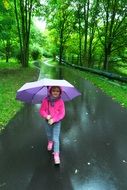 girl under an umbrella walks in the park