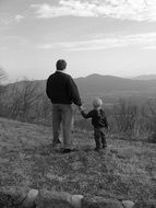 black and white photo of dad with a child on the mountain