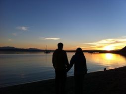 couple walking on the beach at sunset