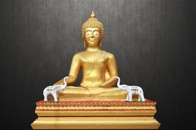 golden buddha statue on gray wall background