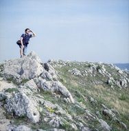 Young boy at top of rock looking away