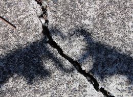 a crack in a stone and a heart-shaped shadow