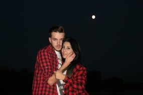 couple in love in plaid shirts on a dark night background