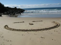 big smile in the sand on the beach