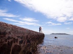 newlyweds on a cliff by the sea