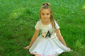 little girl in white on green grass