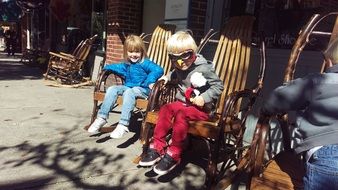 children in suits sit on chairs