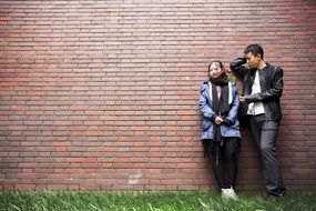 young couple near the brick wall