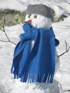 snowman in a long blue scarf on a sunny day