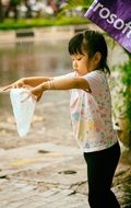 little girl stands in the rain