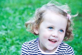 little girl with bright blue eyes in a striped T-shirt