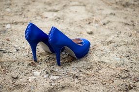 pair of blue high heel Shoes on ground