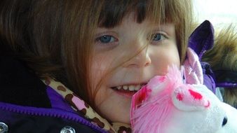 Cute Little Girl with toy at face