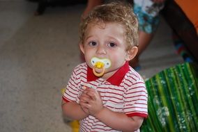 baby in a striped t-shirt with pacifier