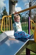 little boy on a hill in a children's park