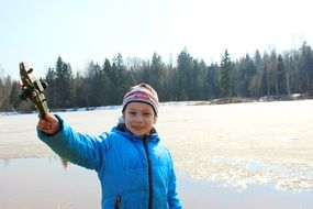 boy with a children's toy in hand on the lake