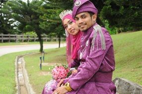 newlyweds on a bench in traditional clothes