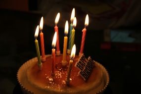 Birthday Cake with colorful candles in darkness