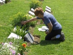 woman kneeling in front of gravestone
