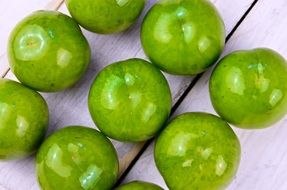 green glossy plums