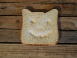 Bread Slice with Happy Face on wooden table