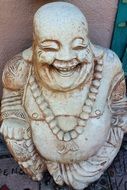 Laughing Buddhac stone statuette