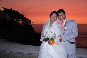 happy newlyweds at sunset