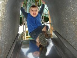 happy kid on a slide at the playground