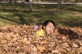 baby in dry fall foliage