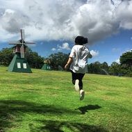 jumping young woman on the green grass