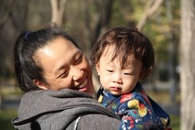 happy cheerful mom with baby in the park