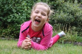 laughing young girl on green grass