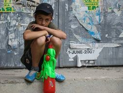 boy playing with a water gun on the street