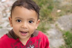 little boy with dark brown eyes close-up on blurred background