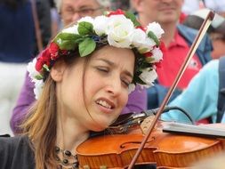 woman in a wreath with a violin on holiday