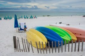 kayaks of different colors on the beach
