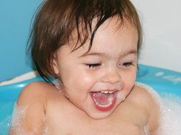 little girl bathes in the bath