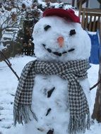 snowman in a scarf around his neck in the street
