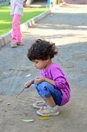 child plays on the pavement