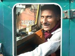 Carman, happy man in Truck cabin, India