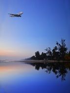 plane over an island in the ocean