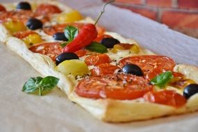 appetizing Tomato Quiche close-up on blurred background
