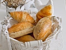 croissants and soft buns in a breakfast basket